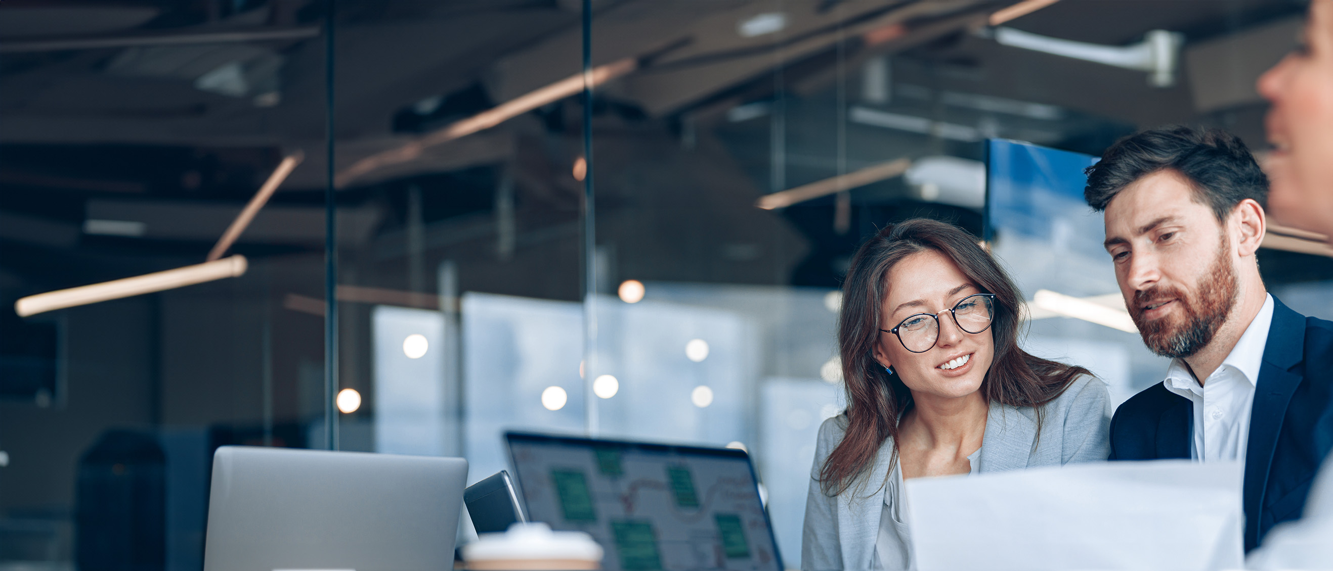 A close up of smiling man and woman revewing docs in a modern office
